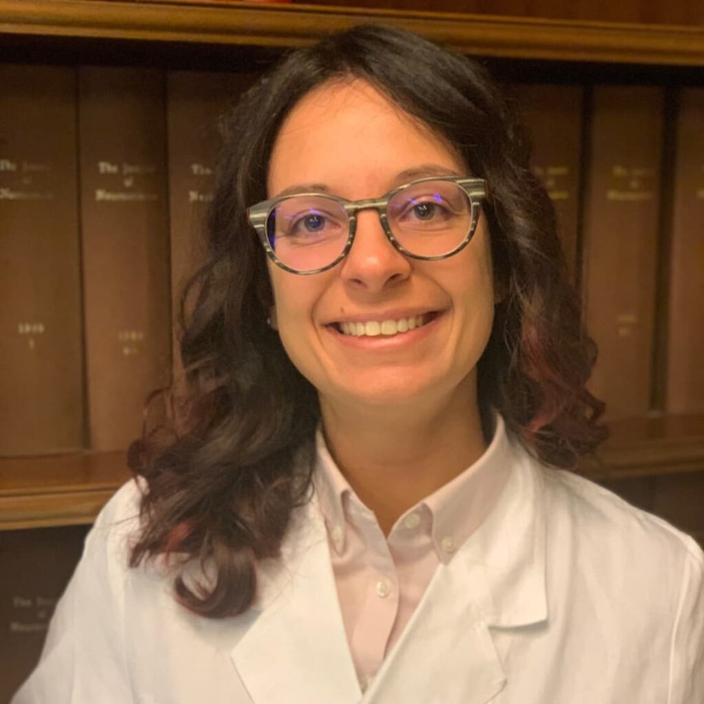 Sara Marriotto smiling at the camera with books in the background